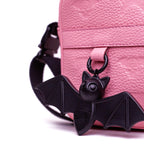 Shinigami Couture pink leather bag detail showing Beep the Bat charm and strap buckle